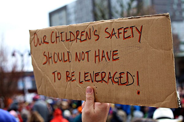 A poster saying "Our children's safety should not have to be leveraged"