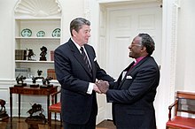 Reagan and Desmond Tutu shaking hands in the Oval Office, 1984