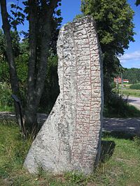 Rune stone, Sweden. With traditional gärdesgård fence in the