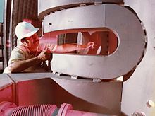 A worker checks the alignment of part of the shaped baseball coils. TMX Baseball Coils.jpg