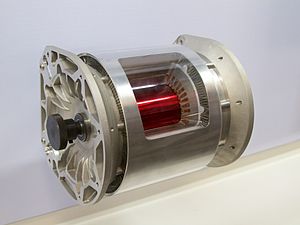 A complete Tesla Model S alternating current electric motor that has had a section removed from the stator to show the rotor inside.