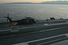 Sunrise on 15 January 2010 as USS Carl Vinson begins helicopter relief operations US Navy 100115-N-5049H-006 An SH-53E Sea Dragon helicopter is on the flight deck of the Nimitz-class aircraft carrier USS Carl Vinson (CVN 70) as the ship arrives off the coast of Haiti.jpg