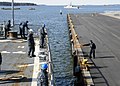 115: US Navy 100505-N-3542S-035 A Finnish line handler throws lines to Sailors aboard the guided-missile destroyer USS Laboon (DDG 58) as Laboon gets underway after a port visit to Helsinki, Finland.jpg