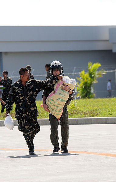 File:A Philippine soldier helps U.S. Navy Lt. Brandon Sheets, a pilot assigned to the "Black Knights" of Helicopter Anti-Submarine Squadron 4, keep a 100-pound sack of rice closed while transporting it to a 080630-N-HX866-009.jpg