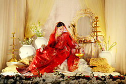 Photograph of a woman wearing a red Jamdani sari