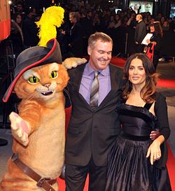 Miller with Salma Hayek pose with a Puss mascot at a premiere of Puss in Boots in Paris