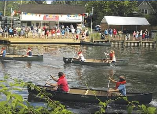 Paddlers race past the Cranford Canoe Club on the Rahway River during the annual Fourth of July competition in Cranford.