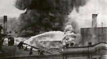 Smoke billows from the roof and back wall of Englert Theatre during 1926 as firemen spray from the roof of the adjoining Parks Transfer building (later Pla-Mor Bowling). Englert Theatre 1926 fire.tif