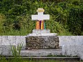 Une croix à Futuna décorée avec des colliers de fleurs.