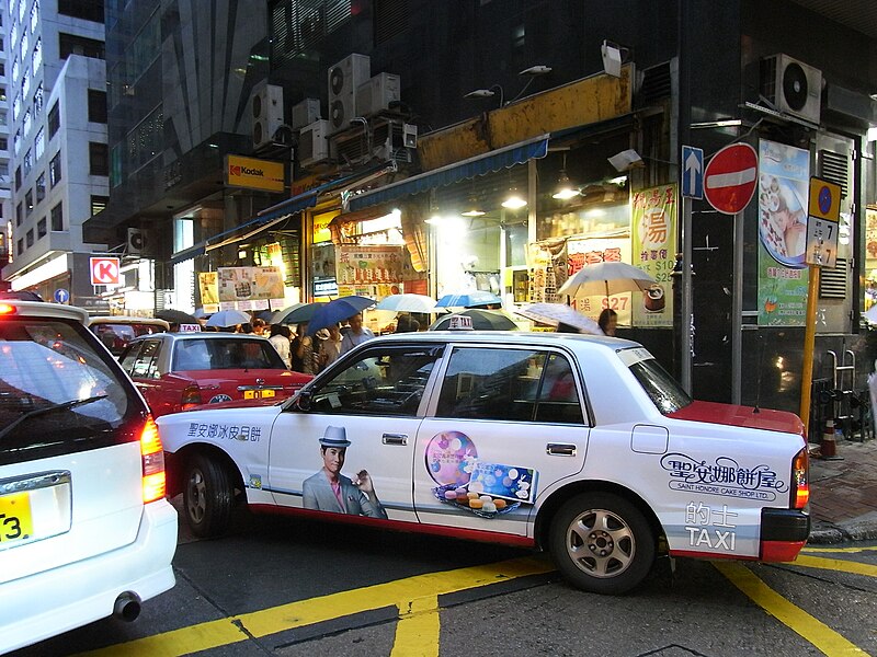 File:HK Sheung Wan Wing Lok Street rain evening Taxi body ads Saint Honore Moon Cake Shop July-2012.JPG