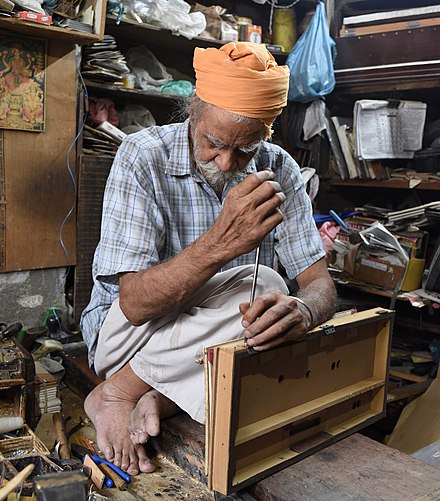 A craftsman repairs a harmonium in his shop in Amritsar, India.