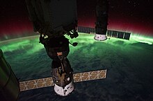 חללית סויוז עוגנת בתחנת החלל הבינלאומית כאשר בכדור הארץ ניתן להבחין בזוהר הדרומי באזור ים טסמן סמוך לדרום ניו זילנד.