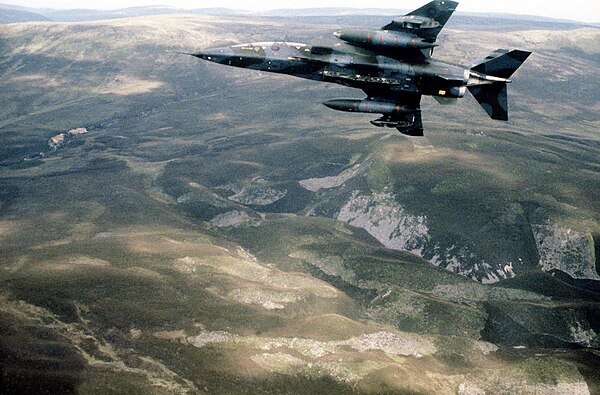 RAF Jaguar T2 in flight displaying underside, 1,187 litre tanks and CBLS (carrier, bomb, light store) fitted to its under-wing pylons.