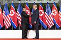 Kim Jong-un ile Donald Trump el sıkışırken arkada Kuzey Kore ve ABD bayrakları