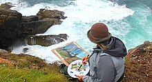 A student attending a "Coast Painting" art course at the school Landscape Painting out door course on a cliff-top near Land's End, Cornwall with Newlyn School of Art, 2012.jpg