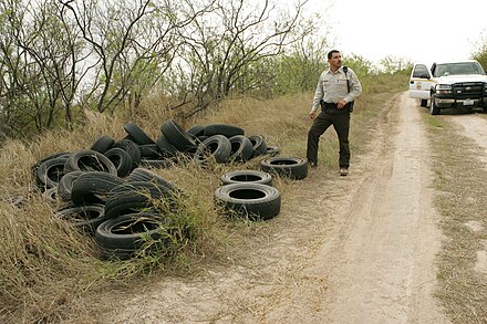 Illegally dumped tires on the side of the road.