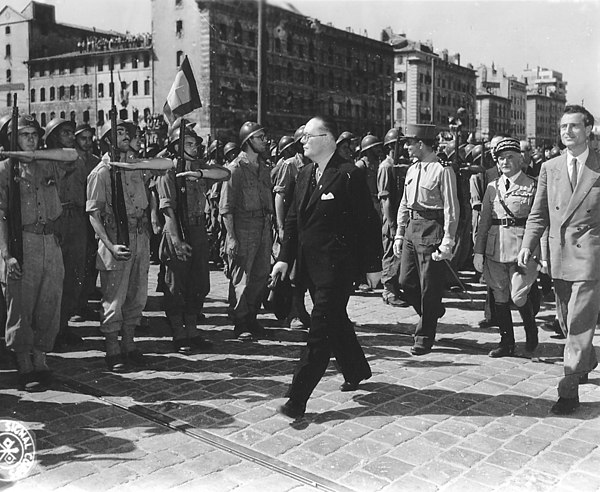 Jean de Lattre de Tassigny (in dark pants and shirt without jacket, behind André Diethelm in suit) reviewing troops in the liberated city of Marseille