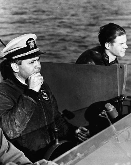 Lieutenant John D. Bulkeley (left) at the helm of a PT boat