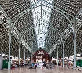 Vista interior do Mercado de Colón (“Mercado de Colombo”), centro de Valência, Espanha. O mercado público, construído entre 1914 e 1916, é um dos principais exemplos da Art nouveau valenciana. Também é declarado Monumento Nacional. O edifício foi concebido e executado pelo arquiteto Francisco Mora Berenguer. Atualmente encontra-se reabilitado e equipado com lojas e estabelecimentos vocacionados para a hotelaria. Foi usado para cobrir as crescentes necessidades do distrito Ensanche, dominado pela classe burguesa. (definição 3 707 × 3 304)