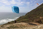 A pair of paragliders take flight at Mussel Rock Beach near Daly City, California.