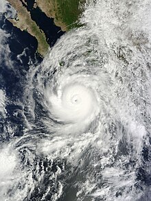 A well developed hurricane approaching Baja California, Mexico, from the south. It features a mostly circular cloud mass surrounding a defined eye.