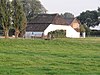 Gepleisterde boerderij onder met riet en pannen gedekt wolfdak