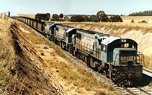 QR loco 2163 and two others haul a coal train away from Boundary Hill loading loop, ~1991.jpg