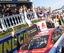 Blaney celebrating after winning the 2017 Axalta presents the Pocono 400 Ryan blaney victory lane (35229940286).jpg