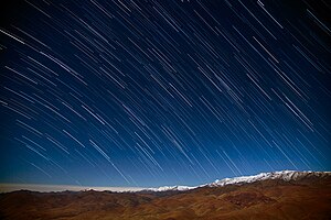 Earth's rotation causes motion blur in long-exposure photos of the night sky. This diurnal motion leaves star trails in exposures like this one taken at La Silla Observatory. Star Rain in the Desert.jpg