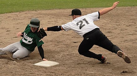 A player trying to avoid a tag at third base.