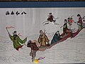 A needlepoint of the Eight Immortals crossing the sea. Lan Caihe is the standing figure second from the right, carrying a flower basket slung on a hoe.