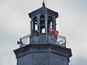 Na wieży ratusza zawisła flaga ze swastyką, oznaczająca zwycięstwo wojsk niemieckich.