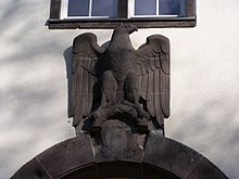 Eagle above the rear main entry to the Robert-Piloty building, department of Computer Science, Darmstadt University of Technology. Note the effaced Swastika under the eagle. Adler, Robert-Piloty-Gebaude, TU Darmstadt.jpg