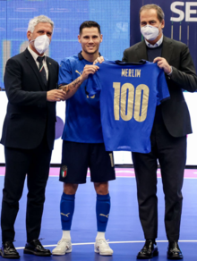 Merlim é agraciado com a camisa comemorativa de suas 100 partidas pela Seleção Italiana de futsal, momentos que antecedem o amistoso contra o Irã em 20 de dezembro de 2021