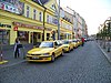 Yellow taxis outside a yellow building in Prague