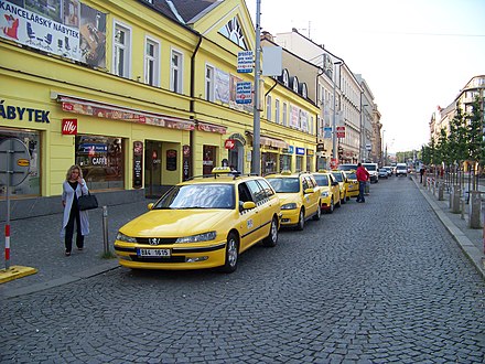 Yellow taxis outside a yellow building in Prague