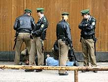 quatre policiers portant une casquette verte.