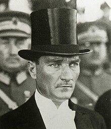 Ataturk with a top hat, a common male headgear in the West at the time (1925). His many reforms secularizing Turkey have made Ataturk the target of Islamist conspiracy theories. Ataturk portrait 2.jpg