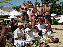 Tropical beaches and Balinese culture are attractions that draw tourists to this popular island resort, such as Melasti rituals performed on the beach. Bali religios ceremoni pa strand med turister.jpg