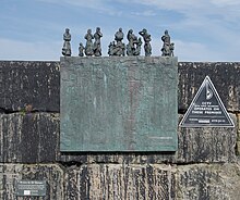 Plaque commemorating the victims of the Eyemouth Disaster on the harbour wall. Burnmouth MMB 02 "Bronze".jpg