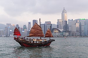 הג'ונקה "דאק לינג" למול חופי נמל ויקטוריה בהונג קונג, לרקע קו הרקיע ההונג-קונגי.