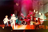 ELO виступають в прямому ефірі у 1981 році під час свого концерту Time Tour. Зліва: Джефф Лінн, Луїс Кларк (на фотографії - затемнений), Луїс Кларк, Бів Бівен та Річард Тенді