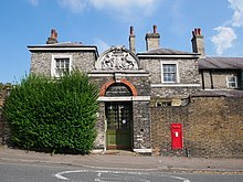 The 19th-century gate and walls around the Merchant Taylor's Almshouses, now Grade II listed