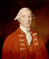 A half-height portrait of Carleton. He wears a red coat with vest, over a white shirt with ruffles. His white hair is drawn back, and he faces front with a neutral expression.