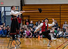 A member of the Stoughton High School Norwegian Dancers performs the hallingkast--"hat kick" at a Wisconsin elementary school. Hat kick.jpg