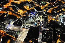 Night-time aerial view, showing Moor Street (bottom left) and New Street (centre-right) stations, separated by the BullRing shopping centre Helicopter - Night Time Photos (8739866055).jpg