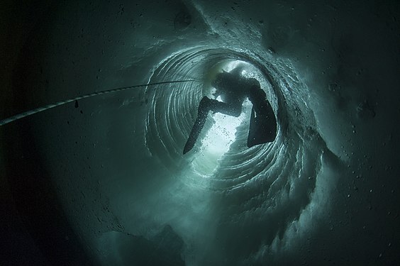 Polar scientific diver at French scientific base in Antarctica. In an ice tube.