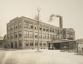 A brick factory with smoke coming out of the chimney