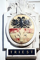 Wappen von Triest auf dem einst von der Marinesektion des k.u.k. Kriegsministeriums genutzten Amtsgebäude Marxergasse 2 in Wien. Im amtlichen Gebrauch der k.u.k. Marine wurden die Namen in italienischer Sprache verwendet.