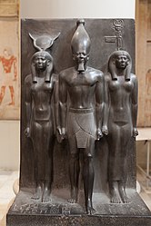 Menkaura flanked by the goddess Hathor (left) and a nome goddess Anput (right). Graywacke statue in Cairo Museum.